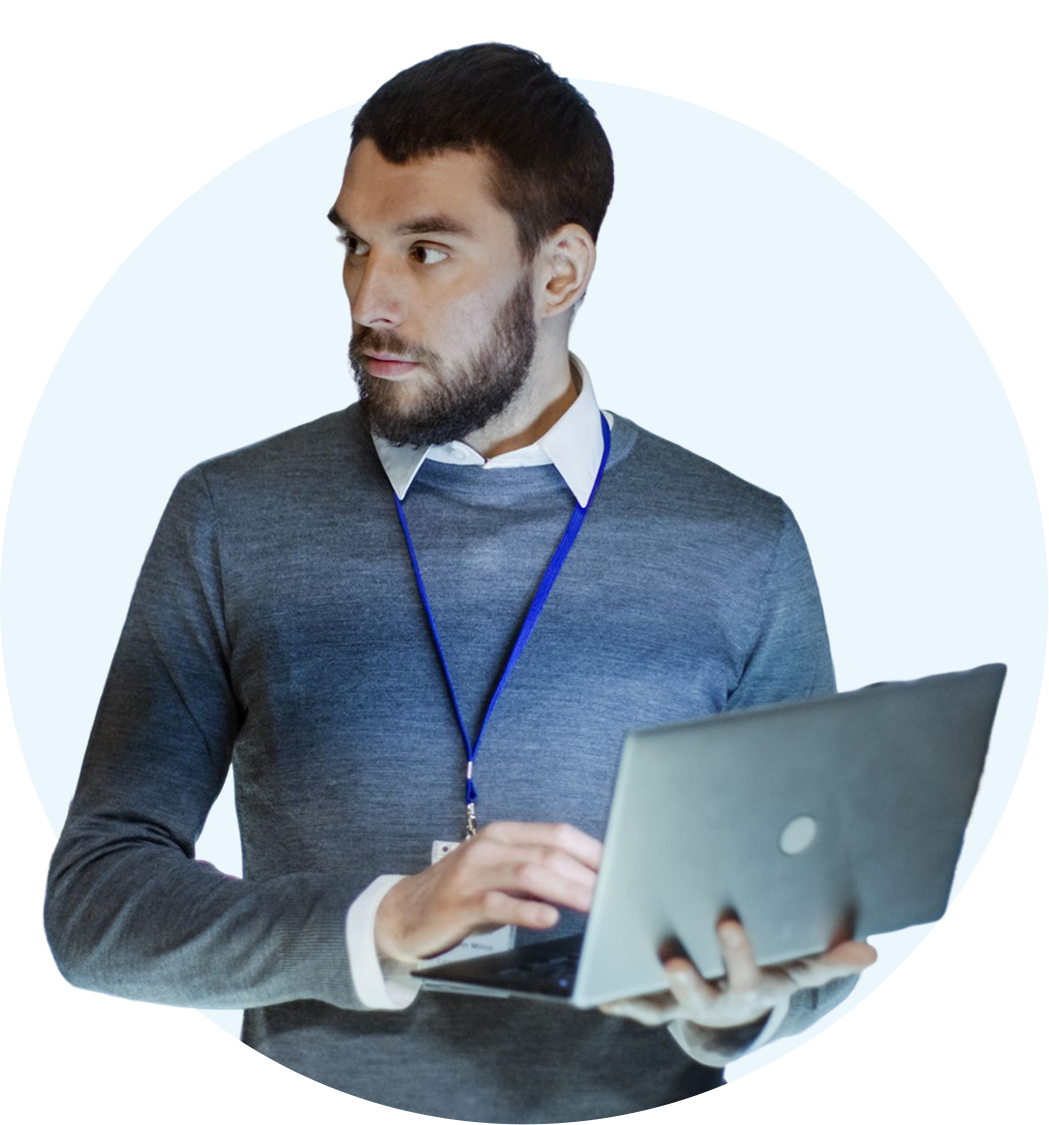 Individual typing on laptop, looking sideways.